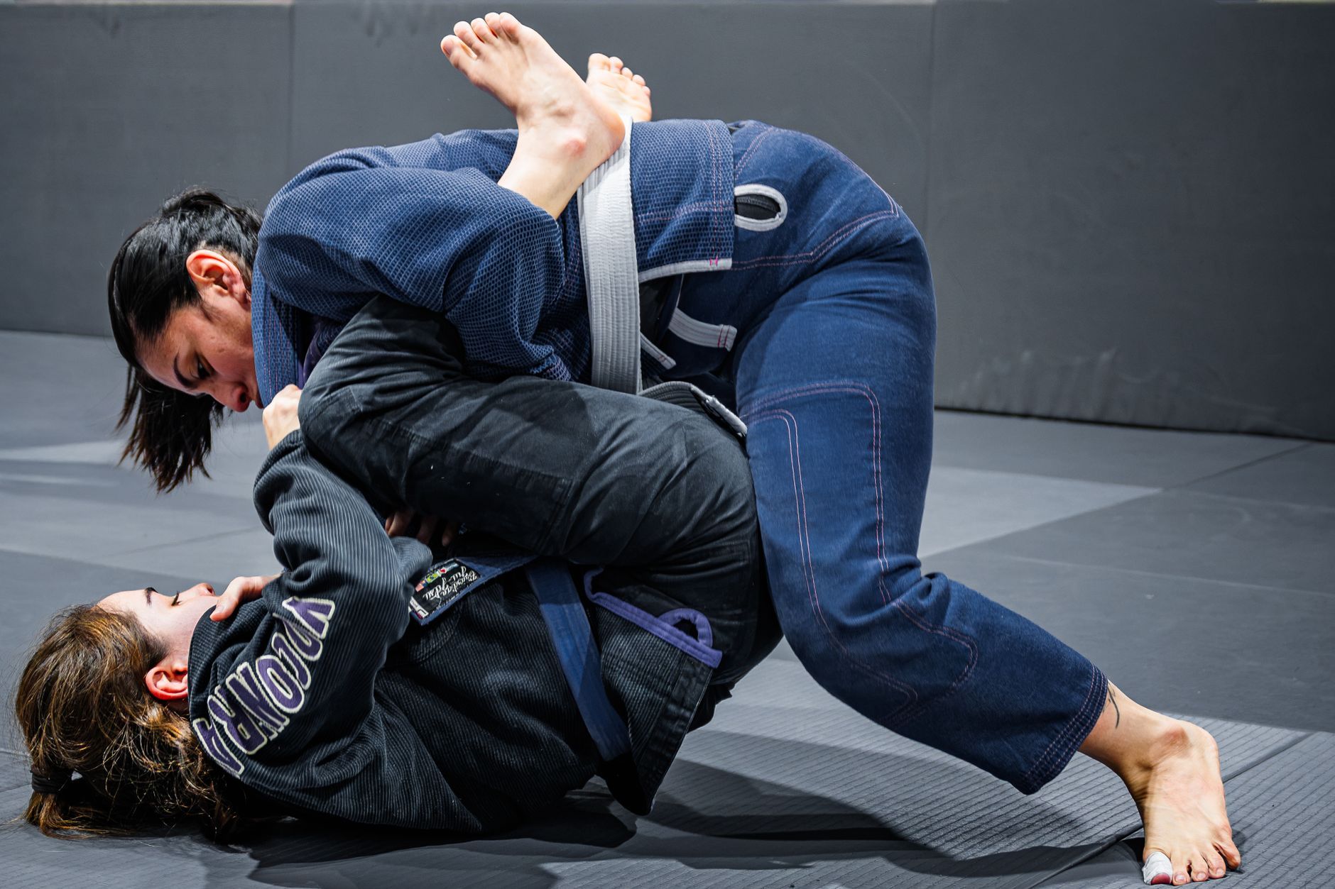 No gi jiu jitsu beginners wearing rash guards practicing underhooks in class